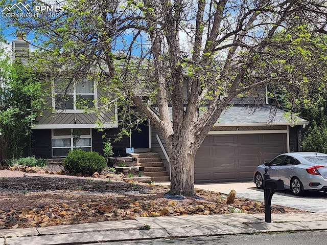 5427 Alteza Dr, Colorado Springs, CO 80917 - view of front of house featuring driveway, an attached garage, and brick siding