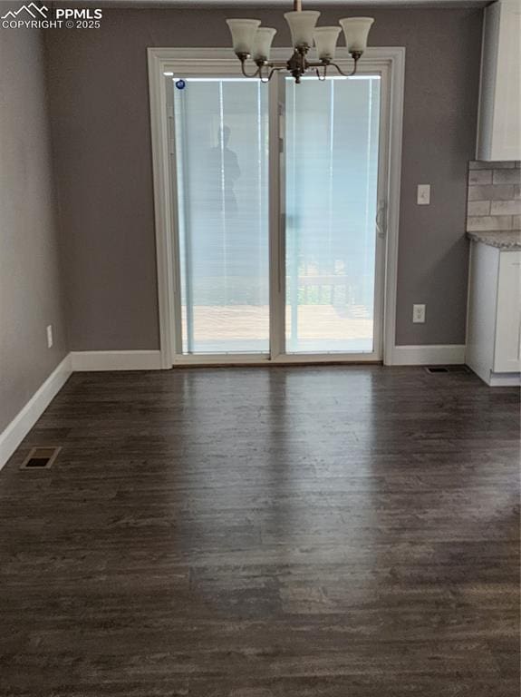 5427 Alteza Dr, Colorado Springs, CO 80917 - unfurnished dining area with baseboards, dark wood-style flooring, and a chandelier