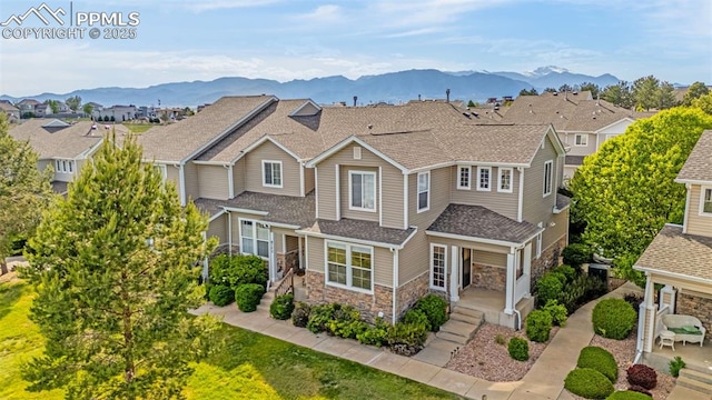 8147 Elk River Vw, Fountain, CO 80817 - view of front of home featuring stone siding, a residential view, a mountain view, and a shingled roof