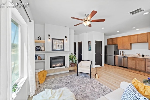 3565 Rosette Grv, Colorado Springs, CO 80910 - living room with a ceiling fan, light wood-style flooring, a glass covered fireplace, and recessed lighting