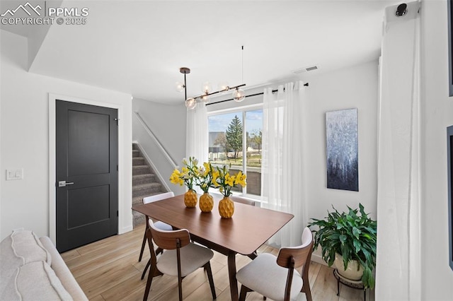 3565 Rosette Grv, Colorado Springs, CO 80910 - dining room with stairway, light wood-style flooring, a chandelier, and baseboards