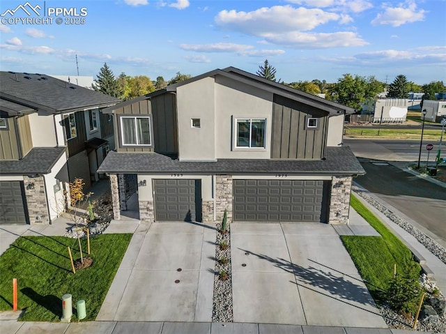 3565 Rosette Grv, Colorado Springs, CO 80910 - view of front facade with board and batten siding, an attached garage, driveway, and stone siding