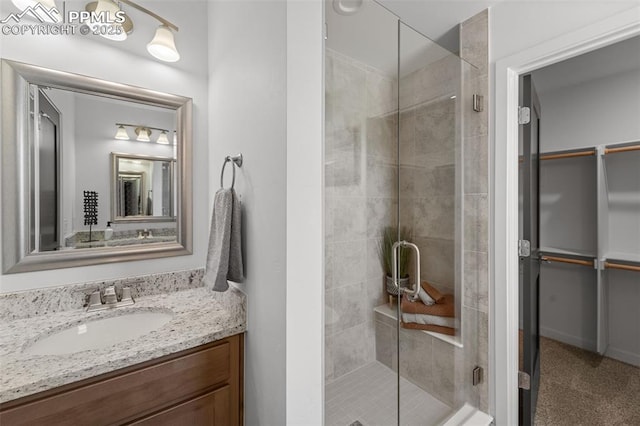 3565 Rosette Grv, Colorado Springs, CO 80910 - bathroom featuring a shower stall, a spacious closet, and vanity