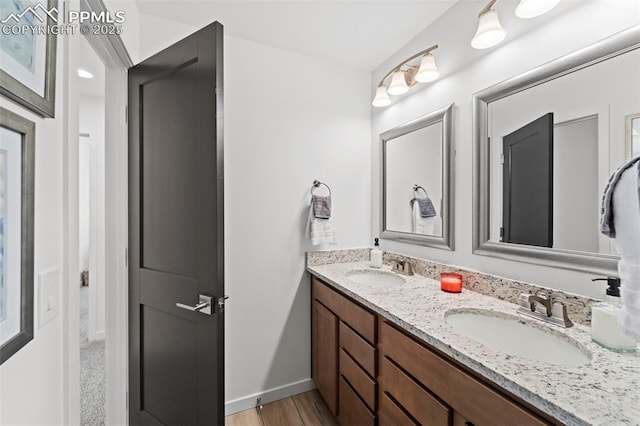 3565 Rosette Grv, Colorado Springs, CO 80910 - bathroom with double vanity, baseboards, and wood finished floors