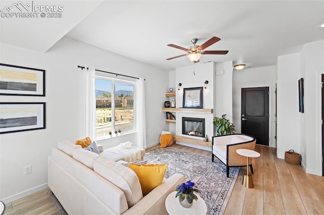 3565 Rosette Grv, Colorado Springs, CO 80910 - living room featuring light wood-style floors, ceiling fan, baseboards, and a glass covered fireplace