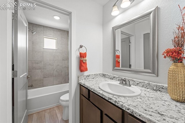 3575 Rosette Grv, Colorado Springs, CO 80910 - bathroom featuring toilet, wood finished floors, vanity, and tub / shower combination