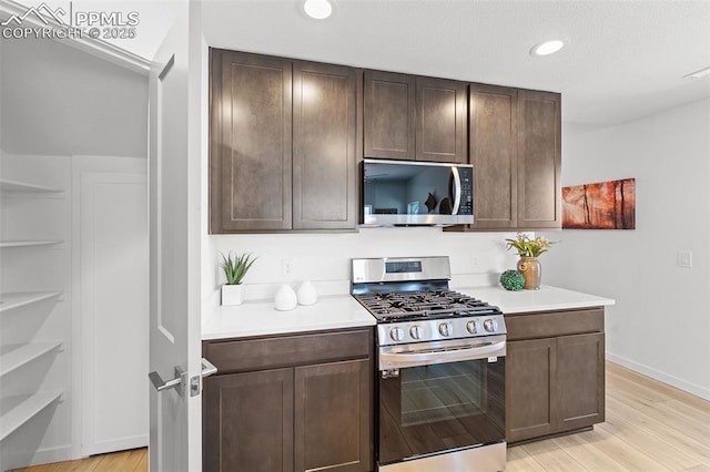 3575 Rosette Grv, Colorado Springs, CO 80910 - kitchen featuring appliances with stainless steel finishes, light countertops, light wood-style flooring, dark brown cabinets, and recessed lighting