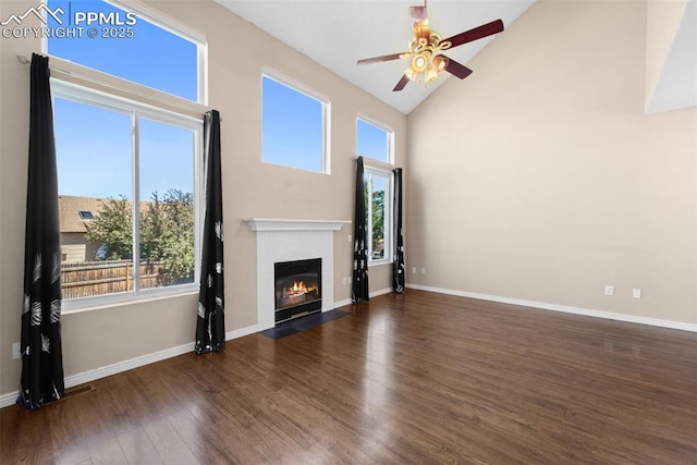 4280 Solarglen Dr, Colorado Springs, CO 80916 - unfurnished living room with ceiling fan, a fireplace with flush hearth, wood finished floors, healthy amount of natural light, and high vaulted ceiling