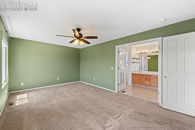 4280 Solarglen Dr, Colorado Springs, CO 80916 - unfurnished bedroom featuring light carpet, baseboards, ensuite bathroom, and a ceiling fan