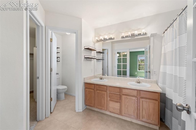 4280 Solarglen Dr, Colorado Springs, CO 80916 - bathroom with double vanity, toilet, and tile patterned flooring
