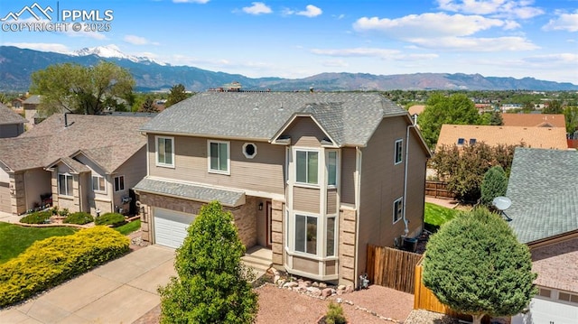4280 Solarglen Dr, Colorado Springs, CO 80916 - traditional home featuring a mountain view, fence, concrete driveway, and a garage
