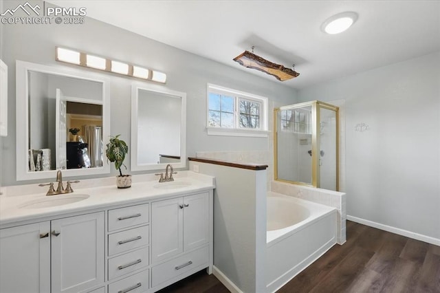 4765 Signal Rock Rd, Colorado Springs, CO 80922 - bathroom with a shower stall, double vanity, wood finished floors, a garden tub, and baseboards