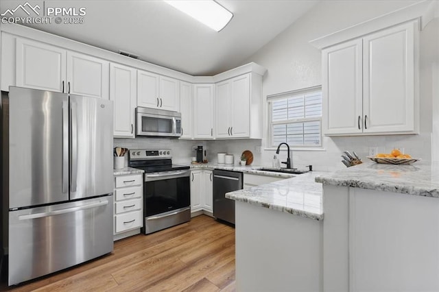 4765 Signal Rock Rd, Colorado Springs, CO 80922 - kitchen featuring appliances with stainless steel finishes, a sink, white cabinets, a peninsula, and light wood-style flooring