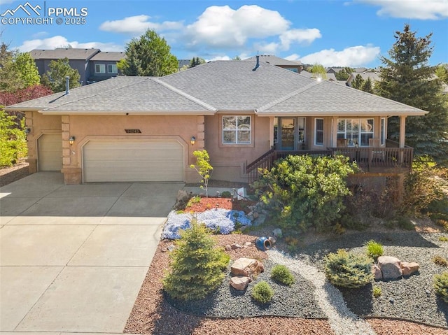 view of front of property featuring an attached garage, roof with shingles, concrete driveway, and stucco siding