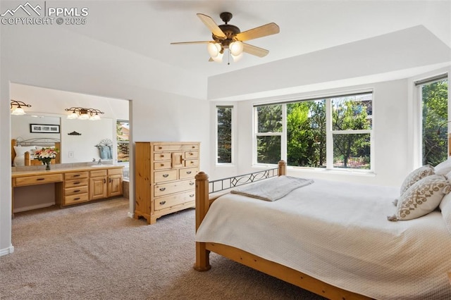 bedroom featuring light colored carpet, a sink, ceiling fan, and a desk