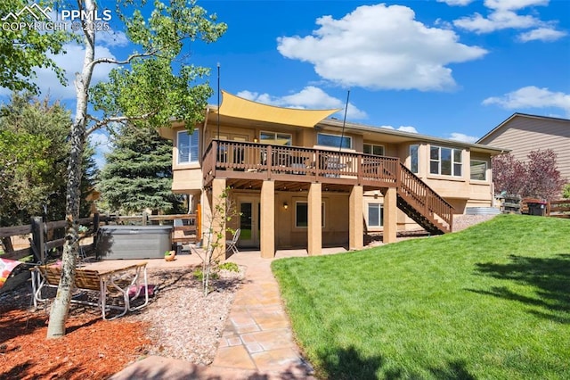 back of house featuring a hot tub, a wooden deck, stairway, a yard, and a patio