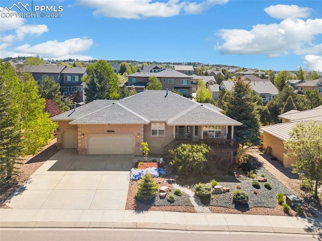 view of front of house with a garage, a residential view, and driveway
