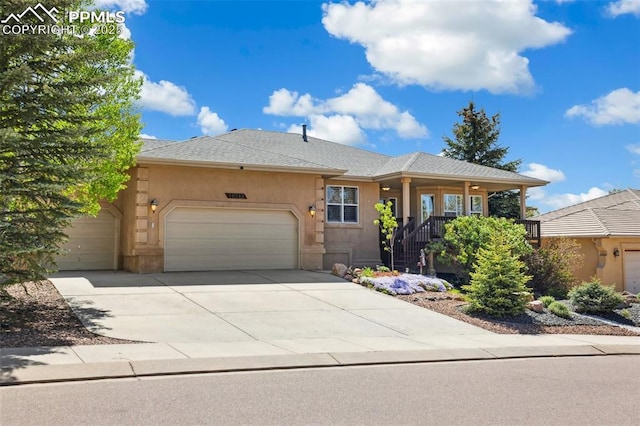 view of front of property with a garage, stucco siding, driveway, and covered porch