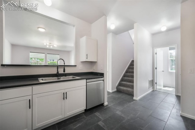 1833 Reilly Grv, Colorado Springs, CO 80951 - kitchen featuring dishwasher, a sink, dark countertops, white cabinetry, and baseboards