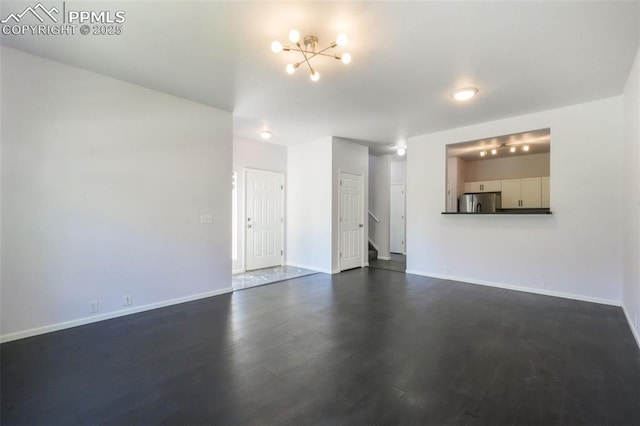 1833 Reilly Grv, Colorado Springs, CO 80951 - unfurnished living room featuring baseboards, dark wood-style flooring, a chandelier, and stairs