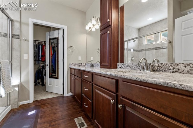 6646 Backcountry Loop, Colorado Springs, CO 80927 - full bath with double vanity, a walk in closet, wood finished floors, and a stall shower