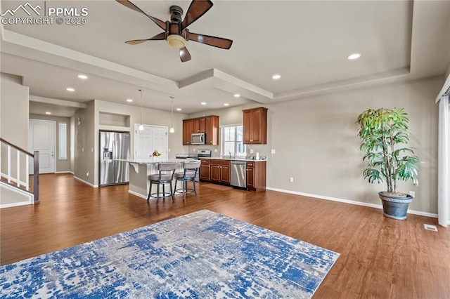 6646 Backcountry Loop, Colorado Springs, CO 80927 - living area featuring a tray ceiling, dark wood-type flooring, a ceiling fan, stairs, and recessed lighting