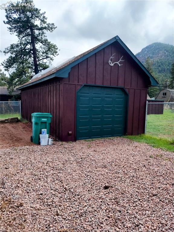 245 Lower Glenway St, Palmer Lake, CO 80133 - detached garage with fence, driveway, and a mountain view