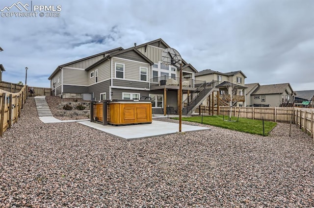 10394 Beckham St, Peyton, CO 80831 - rear view of property featuring a hot tub, a patio area, a fenced backyard, stairway, and board and batten siding