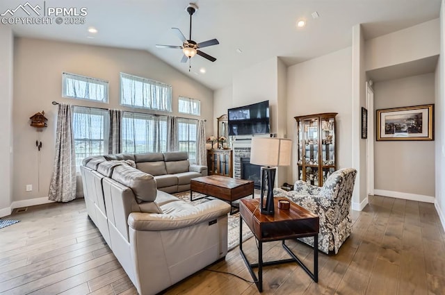 10394 Beckham St, Peyton, CO 80831 - living area with a ceiling fan, a glass covered fireplace, baseboards, high vaulted ceiling, and hardwood / wood-style floors