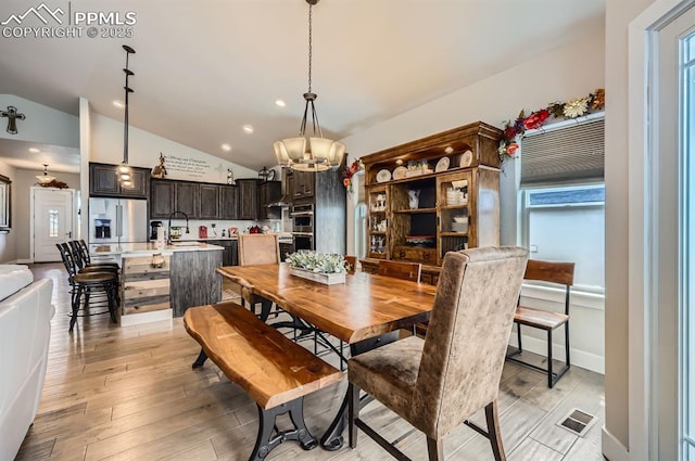 10394 Beckham St, Peyton, CO 80831 - dining room featuring vaulted ceiling, a chandelier, light wood-style flooring, and recessed lighting