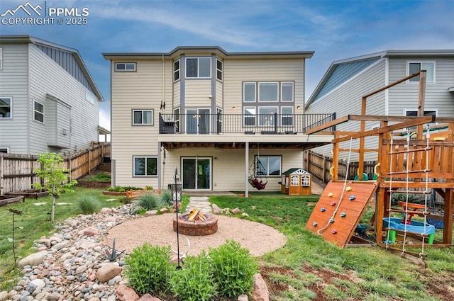 6927 Passing Sky Dr, Colorado Springs, CO 80911 - back of property with an outdoor fire pit, a playground, and a wooden deck
