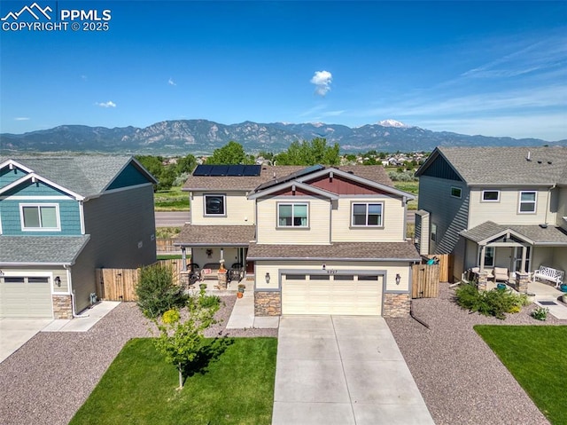6927 Passing Sky Dr, Colorado Springs, CO 80911 - craftsman-style house featuring stone siding, a mountain view, roof mounted solar panels, and a porch