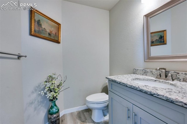 6927 Passing Sky Dr, Colorado Springs, CO 80911 - bathroom featuring vanity, toilet, and wood finished floors