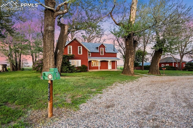 traditional home featuring driveway, a front lawn, and roof with shingles
