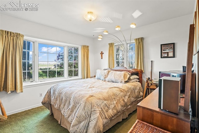 carpeted bedroom featuring multiple windows and baseboards
