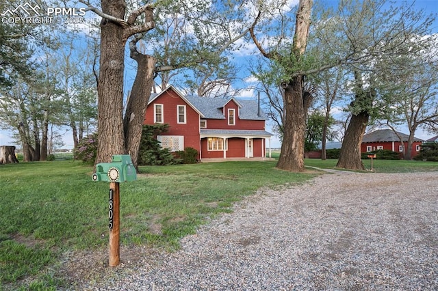 traditional-style house with driveway, a front lawn, roof with shingles, and a garage