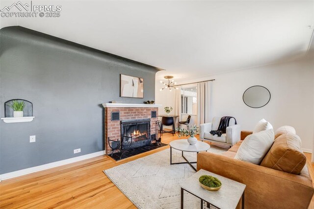 5362 S Cedar St, Littleton, CO 80120 - living area featuring wood finished floors, a chandelier, a fireplace, and baseboards