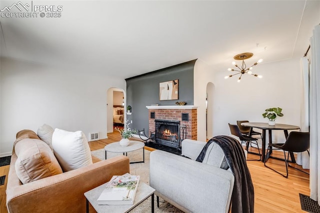 5362 S Cedar St, Littleton, CO 80120 - living area with arched walkways, a chandelier, and light wood finished floors