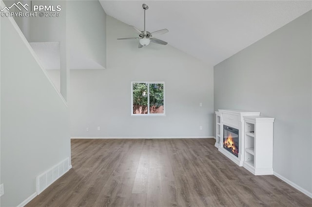 502 Fountain Mesa Rd, Fountain, CO 80817 - unfurnished living room featuring a ceiling fan, lofted ceiling, a glass covered fireplace, wood finished floors, and baseboards