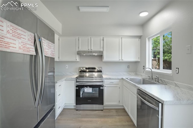 502 Fountain Mesa Rd, Fountain, CO 80817 - kitchen with stainless steel appliances, a sink, under cabinet range hood, light wood-style floors, and light countertops