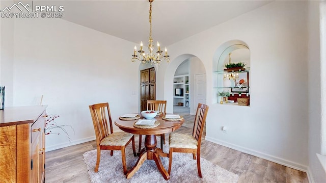 14870 Reiner Ct, Peyton, CO 80831 - dining space featuring arched walkways, light wood finished floors, built in features, and baseboards