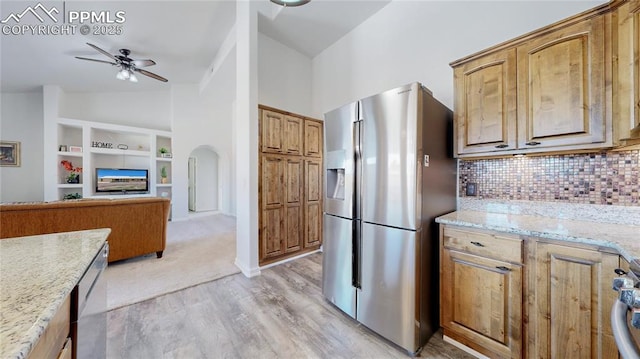14870 Reiner Ct, Peyton, CO 80831 - kitchen featuring stainless steel fridge, a ceiling fan, vaulted ceiling, built in shelves, and backsplash
