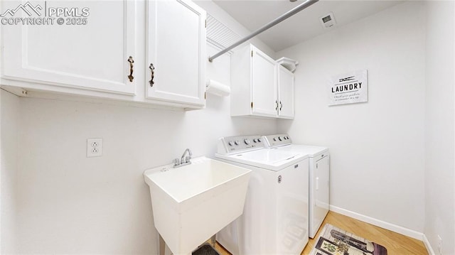 14870 Reiner Ct, Peyton, CO 80831 - laundry room with washer and clothes dryer, light wood-style flooring, cabinet space, and baseboards