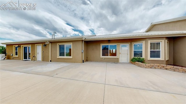 14870 Reiner Ct, Peyton, CO 80831 - view of front facade with stucco siding, a patio, and metal roof