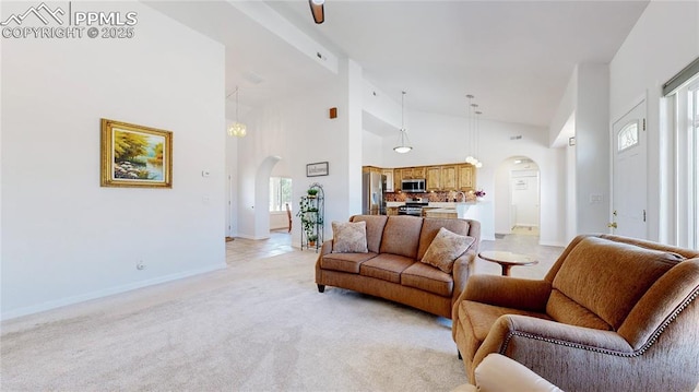 14870 Reiner Ct, Peyton, CO 80831 - living room with arched walkways, high vaulted ceiling, baseboards, and light colored carpet
