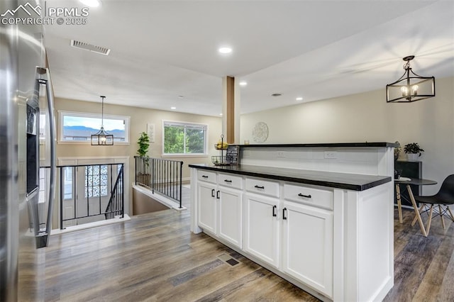 3905 Allgood Dr, Colorado Springs, CO 80911 - kitchen featuring a chandelier, dark countertops, wood finished floors, white cabinets, and pendant lighting