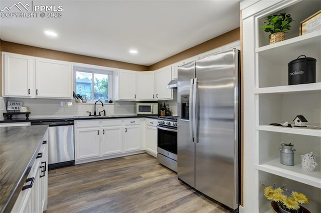 3905 Allgood Dr, Colorado Springs, CO 80911 - kitchen featuring appliances with stainless steel finishes, open shelves, a sink, dark countertops, and under cabinet range hood