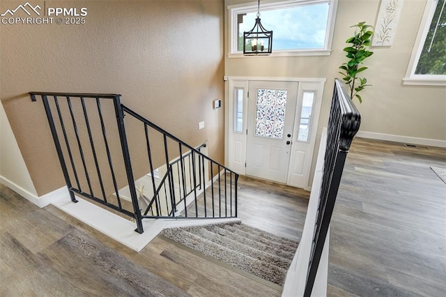 3905 Allgood Dr, Colorado Springs, CO 80911 - entrance foyer with wood finished floors, a chandelier, baseboards, and stairway