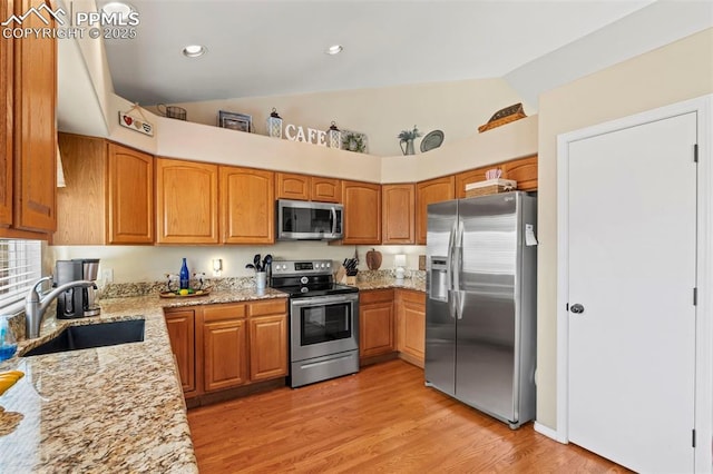 4298 Apache Plume Dr, Colorado Springs, CO 80920 - kitchen with stainless steel appliances, a sink, light stone counters, light wood-style flooring, and brown cabinets