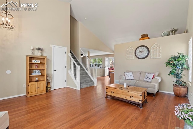 4298 Apache Plume Dr, Colorado Springs, CO 80920 - living area with stairway, light wood finished floors, high vaulted ceiling, a chandelier, and baseboards